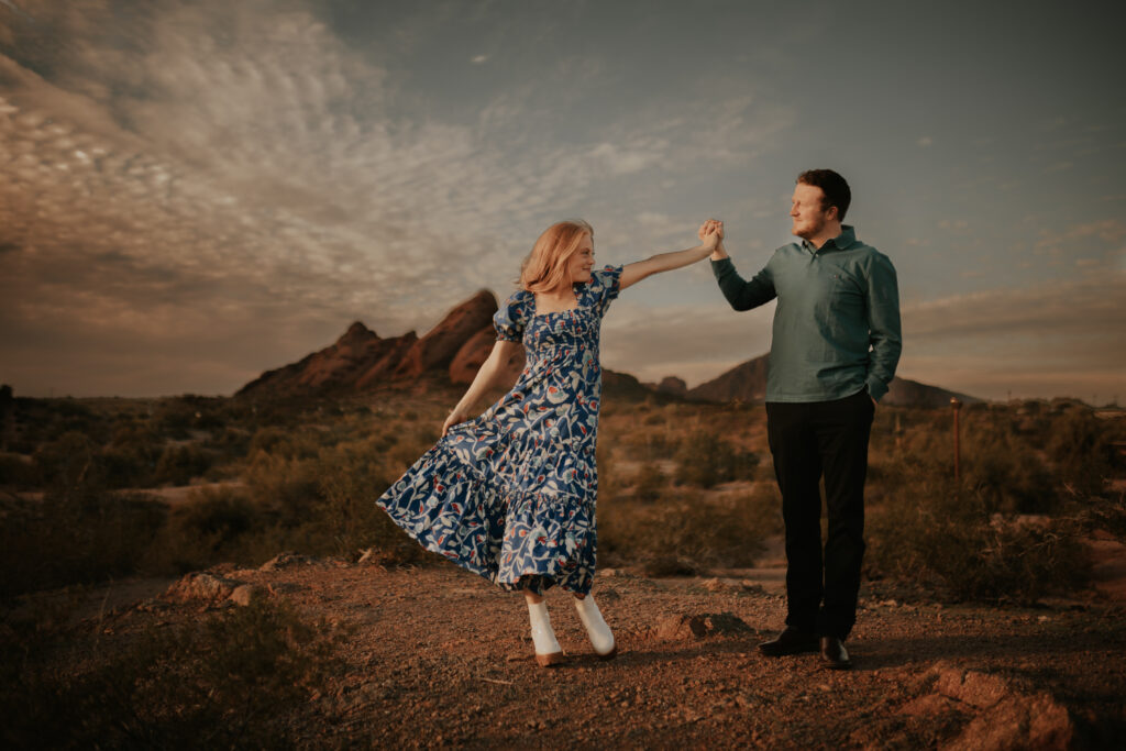 A couple, dancing on top of a mountain with a sunset behind them. 